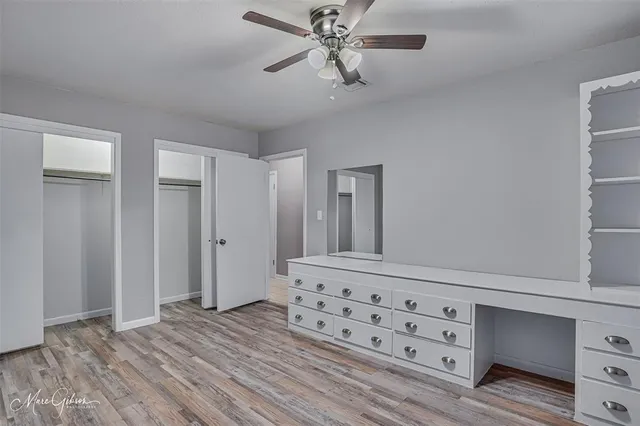 a view of a hallway with closet and chandelier fan