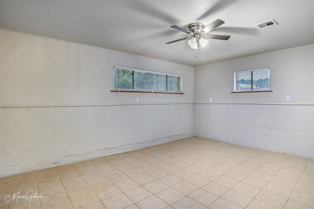 821 Princeton Road Princeton, LA 71067 - Photo 19 of 26 an empty room with a chandelier fan and windows