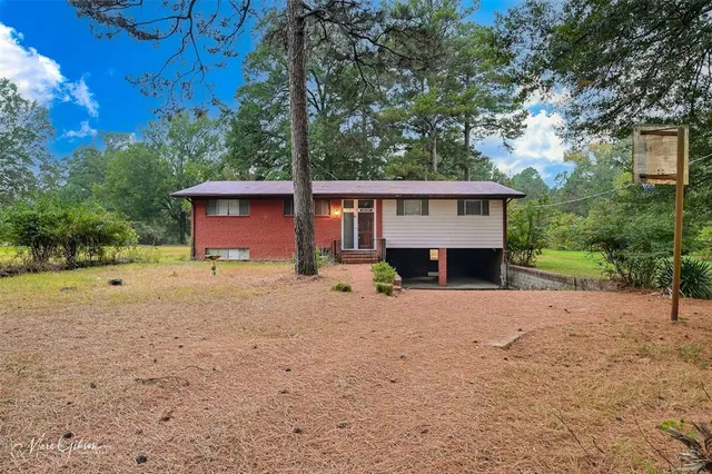 a front view of a house with a yard and tree s