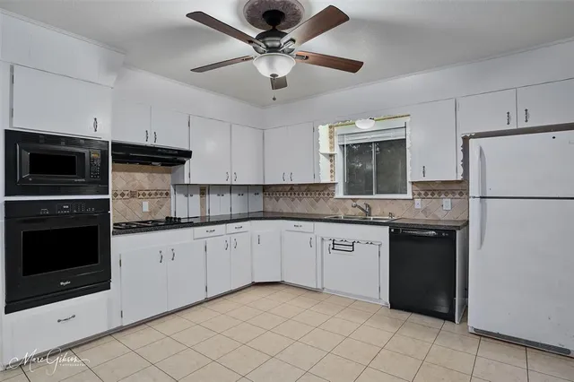 a kitchen with granite countertop appliances cabinets and a sink