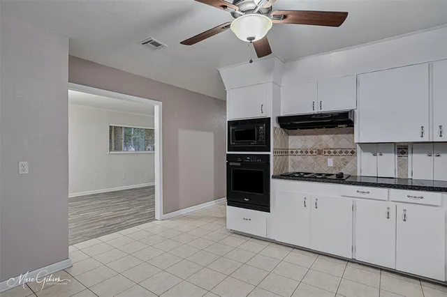 a kitchen with granite countertop a sink and cabinets