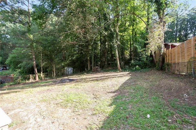 a view of a yard with plants and trees