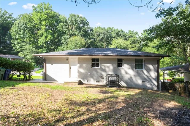 a front view of house with yard and trees in the background