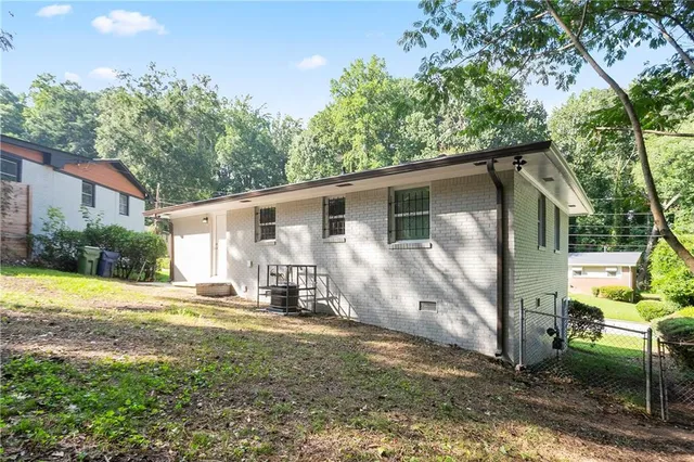 a view of a house with backyard and sitting area