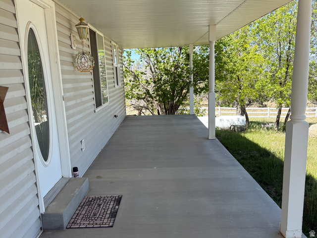 10000 North 6730th East Spring City, UT 84662 - Photo 20 of 31 Expansive covered concrete porch featuring white siding, multiple windows, and decorative support columns