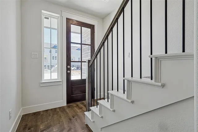 a view of a hallway with wooden floor and staircase