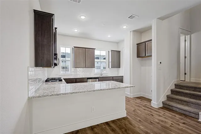 a kitchen with granite countertop cabinets stainless steel appliances and a counter space