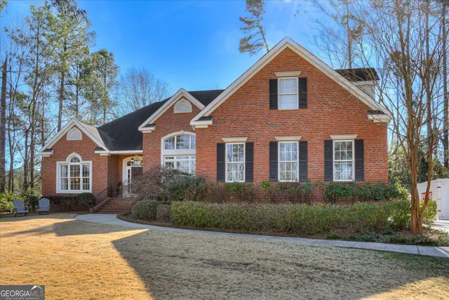 a front view of a house with a yard and trees