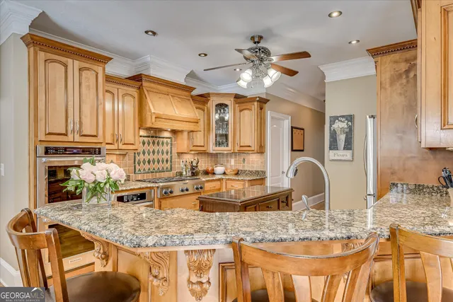 a kitchen with stainless steel appliances granite countertop a refrigerator a stove and a dining table with wooden floor