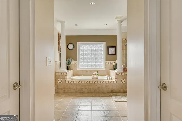 a bedroom with a bed a flat tv screen and dresser