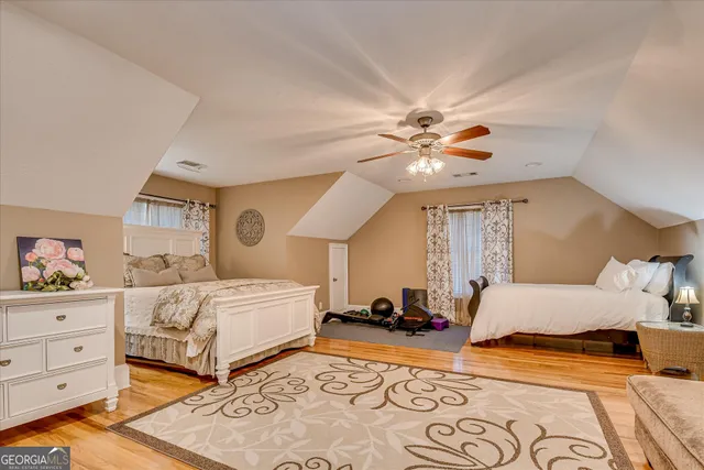 a view of a yard with plants and large trees