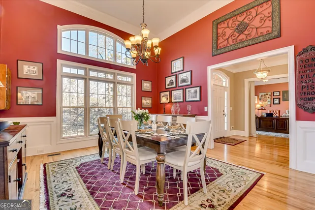 a view of a dining room with furniture a chandelier and wooden floor