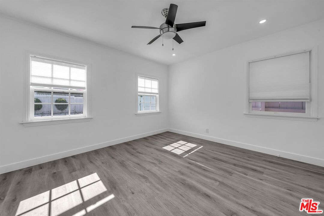 121 North Doheny Drive Beverly Hills, CA 90211 - Photo 11 of 20 a view of an empty room with a window and wooden floor