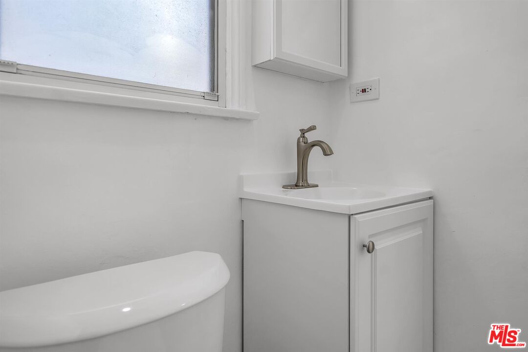 121 North Doheny Drive Beverly Hills, CA 90211 - Photo 14 of 20 a bathroom with a sink a toilet and mirror