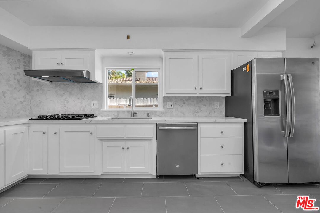 121 North Doheny Drive Beverly Hills, CA 90211 - Photo 6 of 20 a kitchen with stainless steel appliances granite countertop a refrigerator and a stove