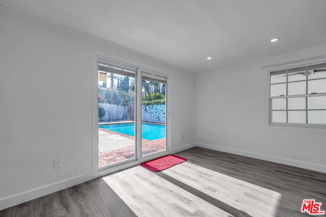 121 North Doheny Drive Beverly Hills, CA 90211 - Photo 8 of 20 an empty room with wooden floor and windows