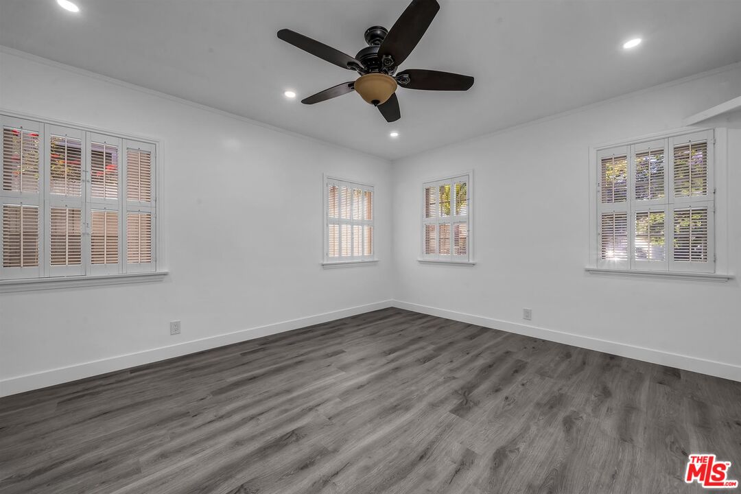 121 North Doheny Drive Beverly Hills, CA 90211 - Photo 9 of 20 a view of an empty room with wooden floor and a window