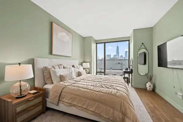 a bedroom with a bed a mirror and lamp