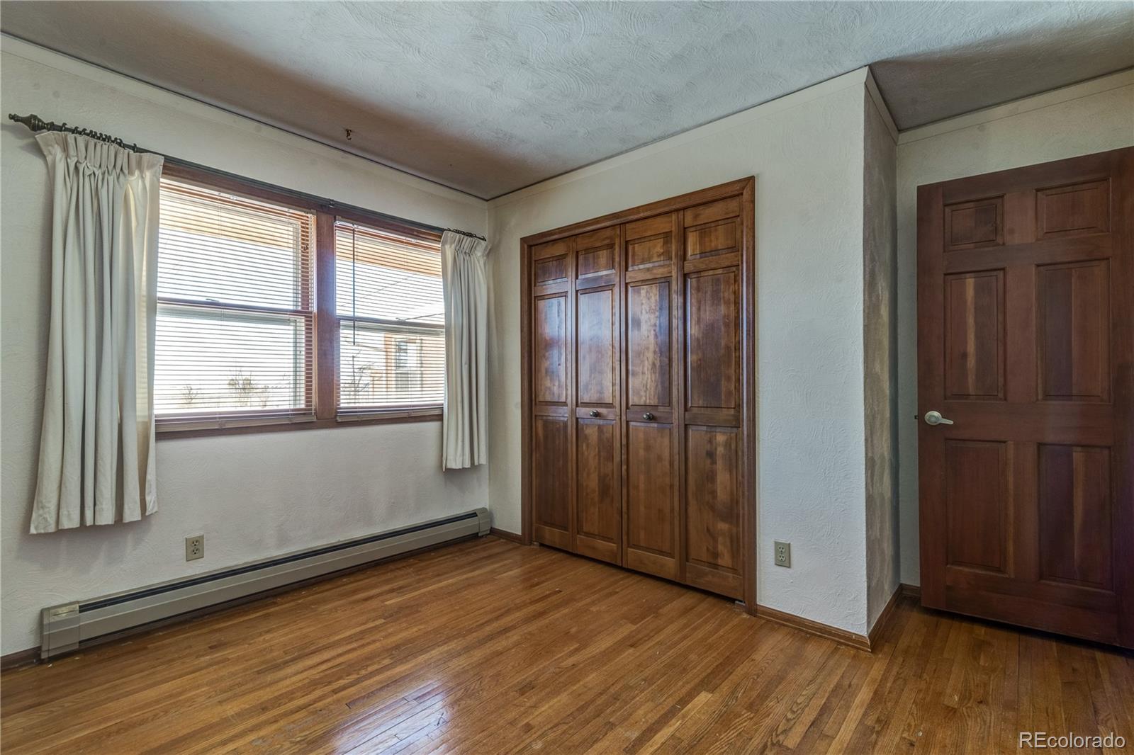 16065 Jones Road Peyton, CO 80831 - Photo 15 of 29 an empty room with wooden floor and windows