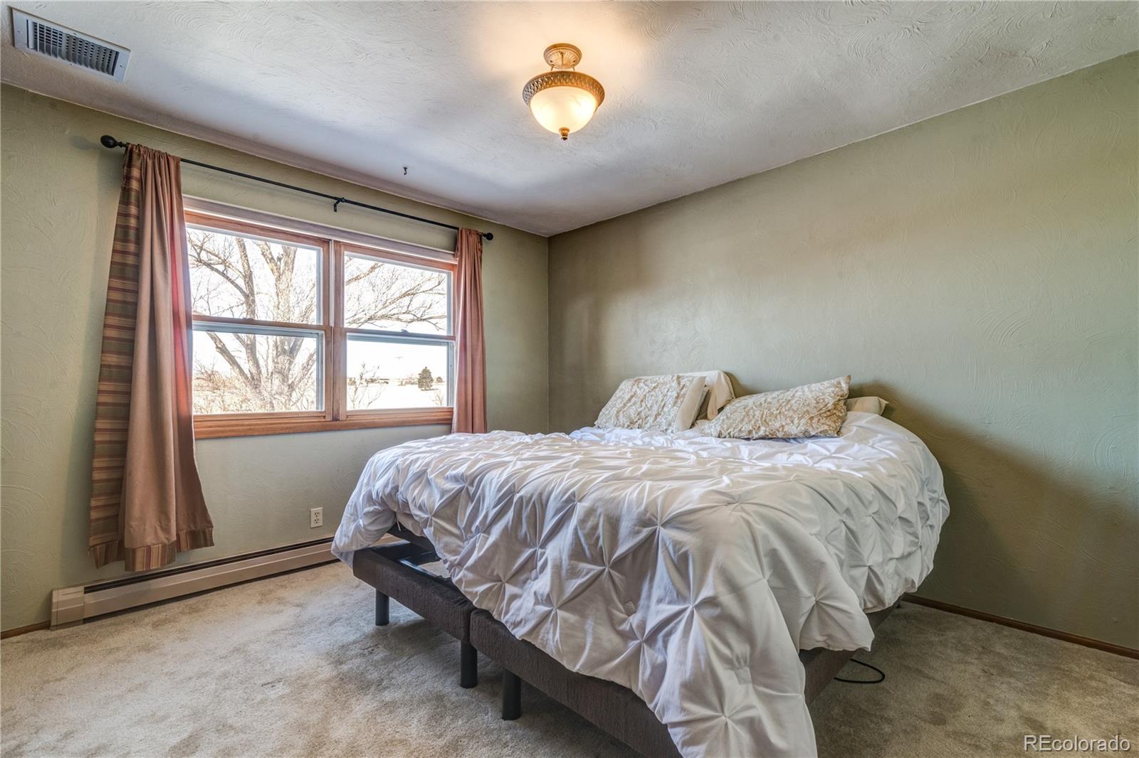 16065 Jones Road Peyton, CO 80831 - Photo 17 of 29 a bed sitting in a bedroom next to a window