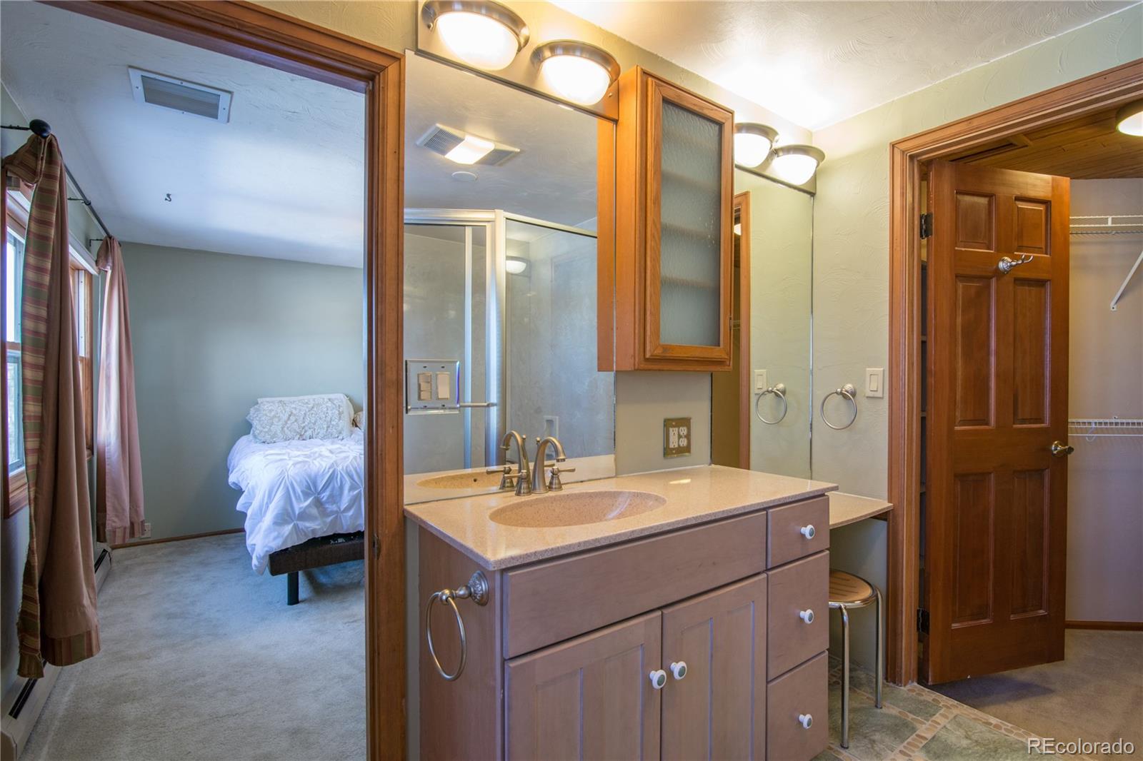 16065 Jones Road Peyton, CO 80831 - Photo 19 of 29 a en suite bathroom with a sink vanity and a mirror