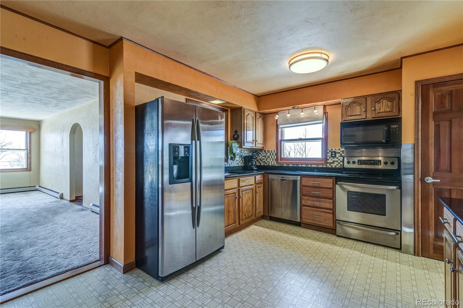 16065 Jones Road Peyton, CO 80831 - Photo 3 of 29 a kitchen with stainless steel appliances granite countertop a refrigerator and a stove top oven