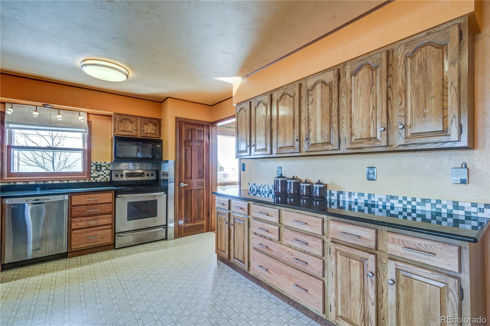 16065 Jones Road Peyton, CO 80831 - Photo 4 of 29 a kitchen with granite countertop white cabinets and stainless steel appliances