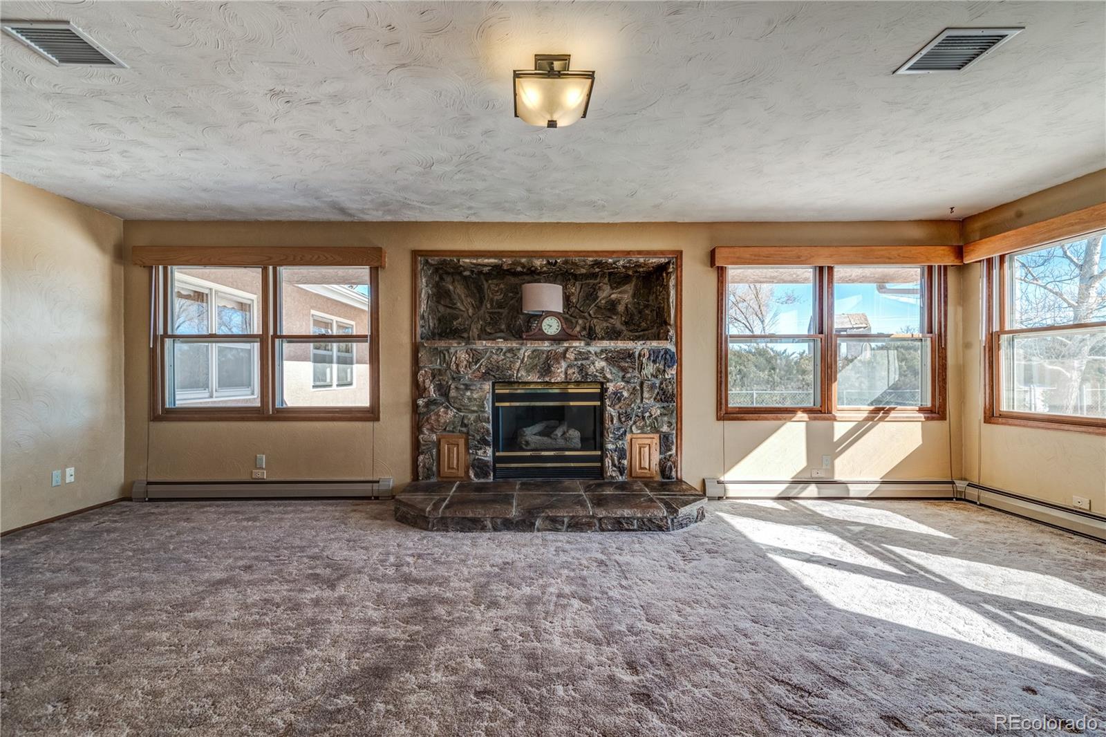 16065 Jones Road Peyton, CO 80831 - Photo 7 of 29 an empty room with floor to ceiling window and fireplace