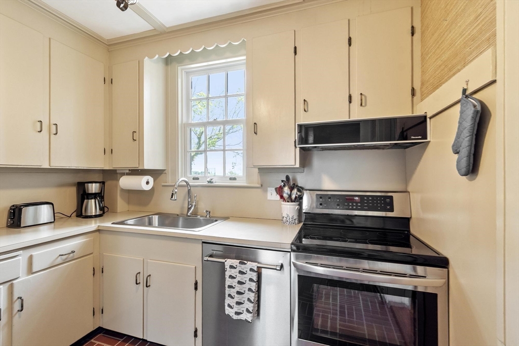 89 Lothrop Street Beverly, MA 01915 - Photo 19 of 41 a kitchen with a stove and white cabinets