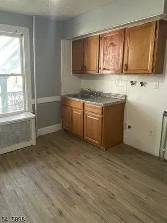 a kitchen with granite countertop a sink and a stove top oven
