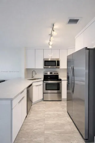 a kitchen with stainless steel appliances a refrigerator sink and stove