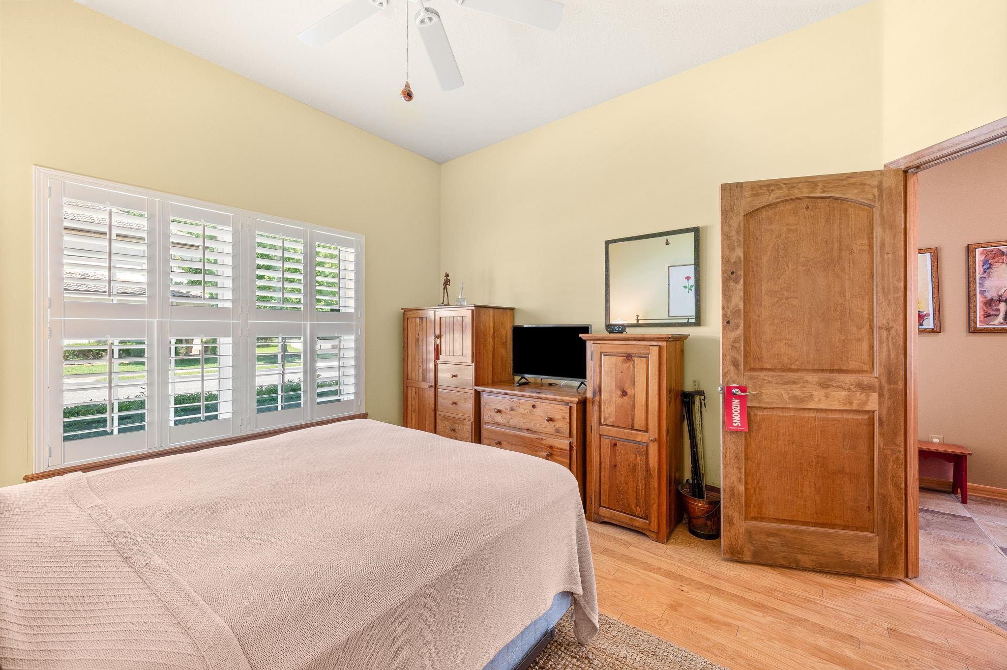 99 Grand Ravine Drive St. Augustine, FL 32086 - Photo 35 of 42 a bedroom with a bed flat screen tv and a large window