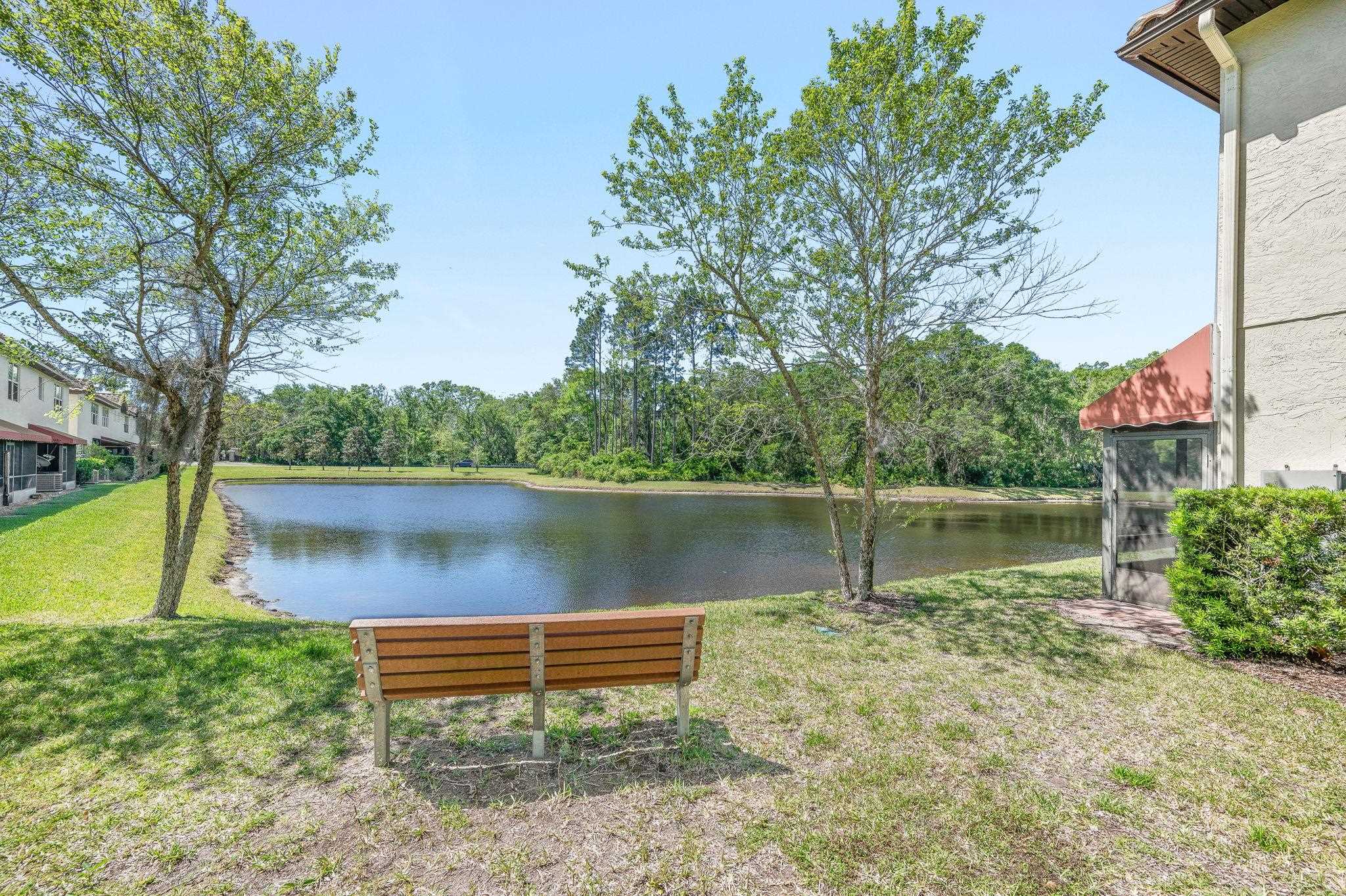 99 Grand Ravine Drive St. Augustine, FL 32086 - Photo 41 of 42 a lake view with a bench and trees around