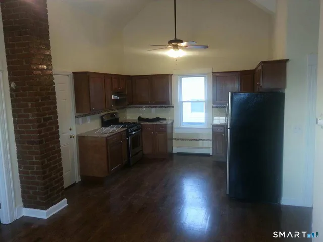 a kitchen with a sink a refrigerator and cabinets
