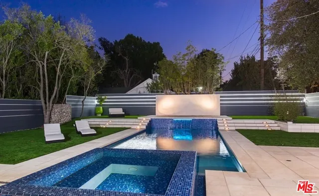 a view of a wooden deck and a yard with swimming pool
