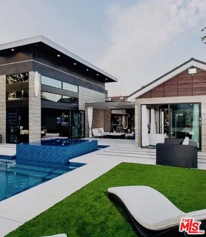 a view of a house with a yard potted plants and a table