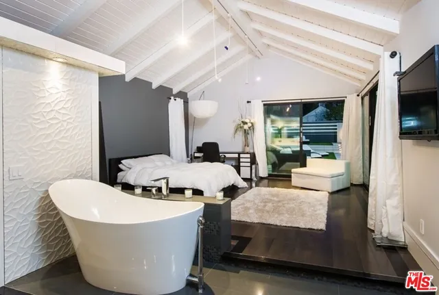 a living room with a floor to ceiling window and an outdoor view