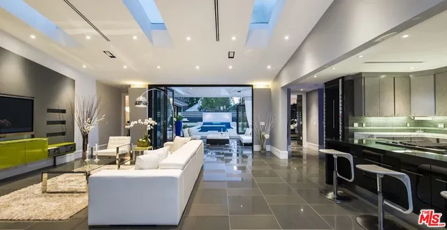 a living room with furniture a flat screen tv and a large window