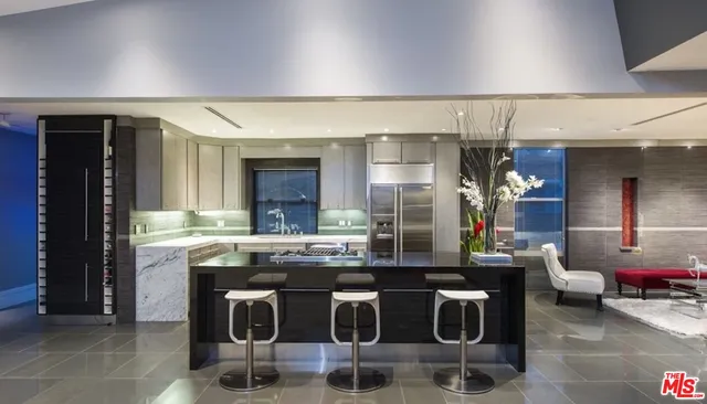 a dining hall with stainless steel appliances kitchen island granite countertop a dining table and chairs