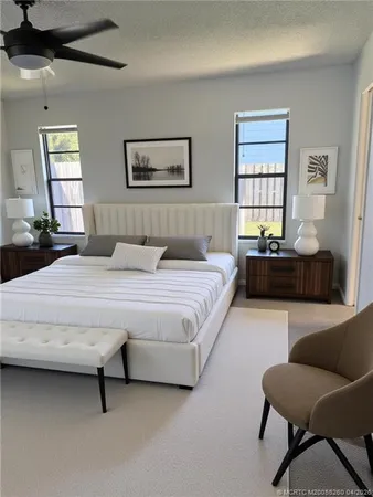 a bedroom with a bed couch and windows