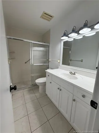 a bathroom with a double vanity sink toilet and shower