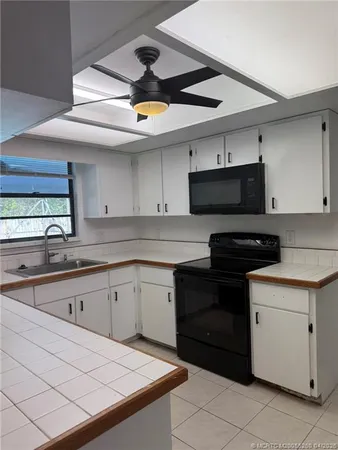 a kitchen with a sink a stove and cabinets