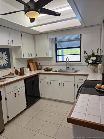 a kitchen with a sink dishwasher and white cabinets