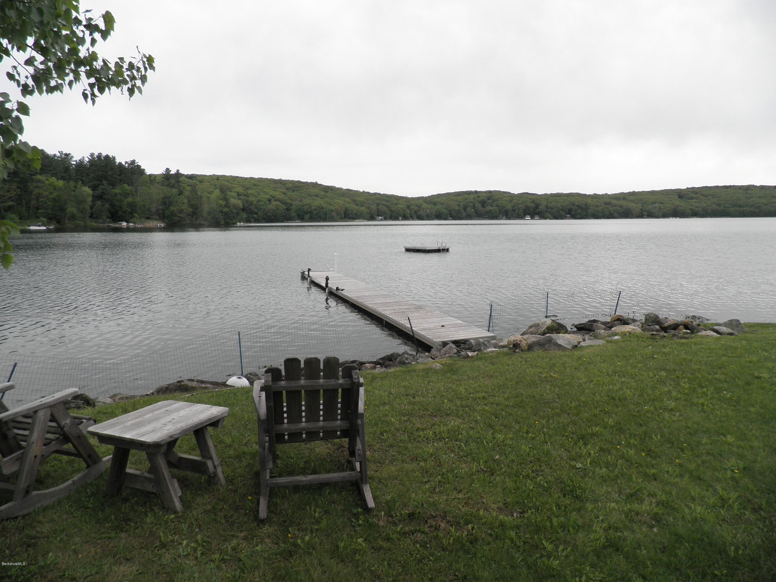 63 A Goose Pond Road Tyringham, MA 01238 - Photo 3 of 5 a view of a lake with table and chairs