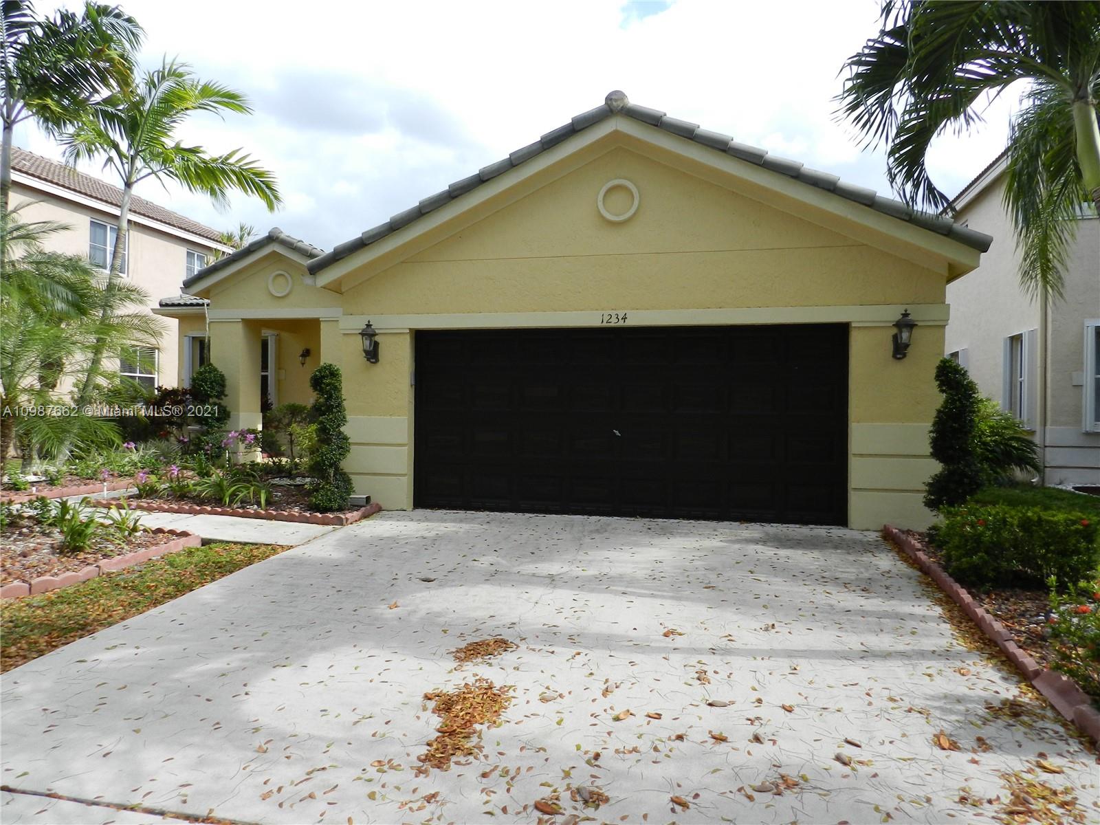 1234 Chenille Circle Weston, FL 33327 - Photo 2 of 35 a front view of a house with a yard and garage