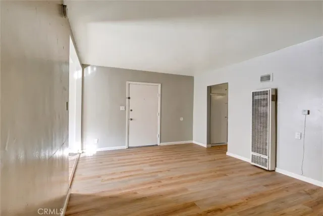 a view of an empty room with wooden floor