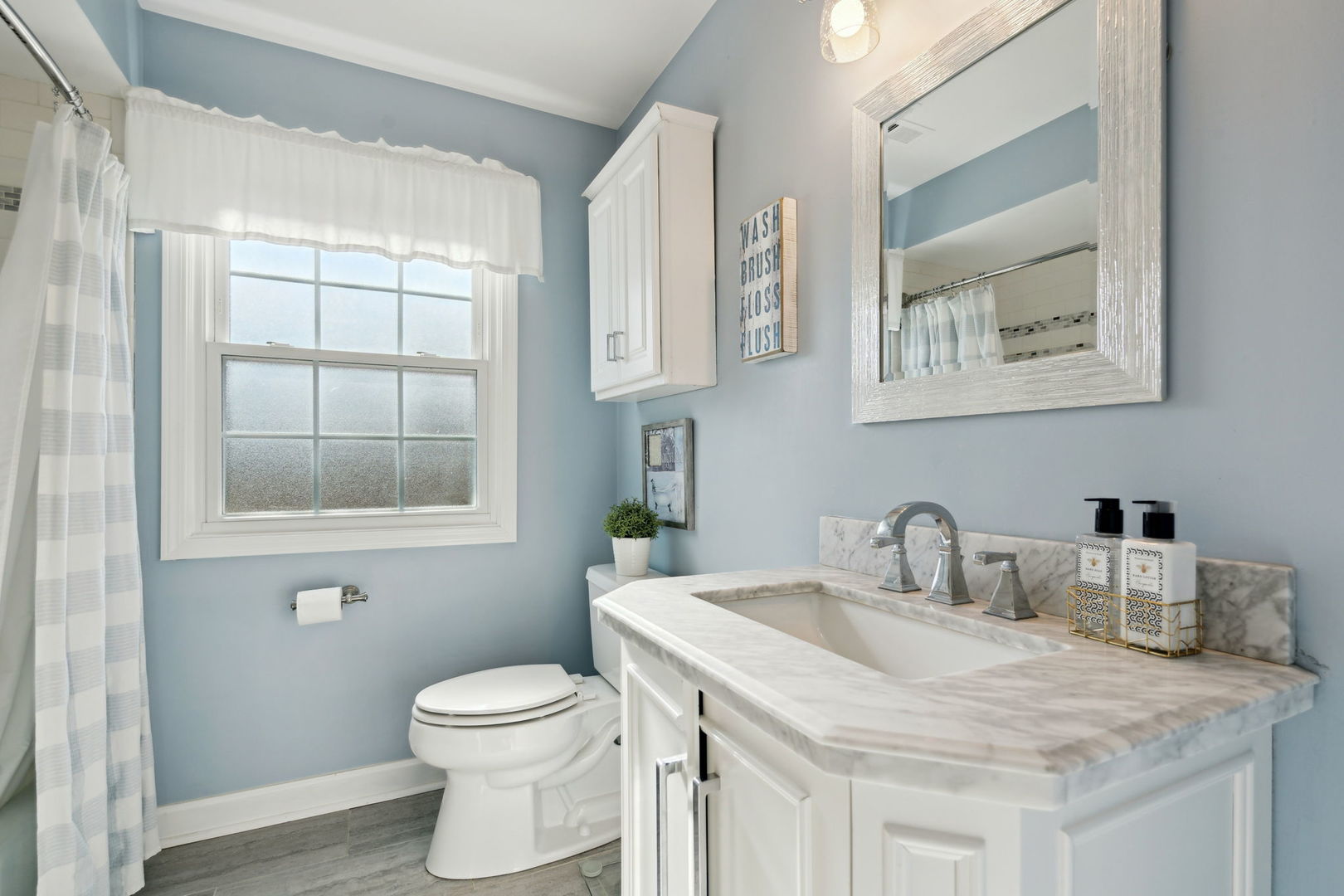 1246 Edward Road Naperville, IL 60540 - Photo 17 of 21 a bathroom with a granite countertop sink a toilet and a window