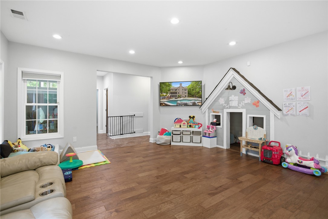 207 Devonhurst Drive Seneca, SC 29678 - Photo 31 of 50 This versatile recreation room offers ample space for various activities, featuring hardwood flooring and bright recessed lighting.