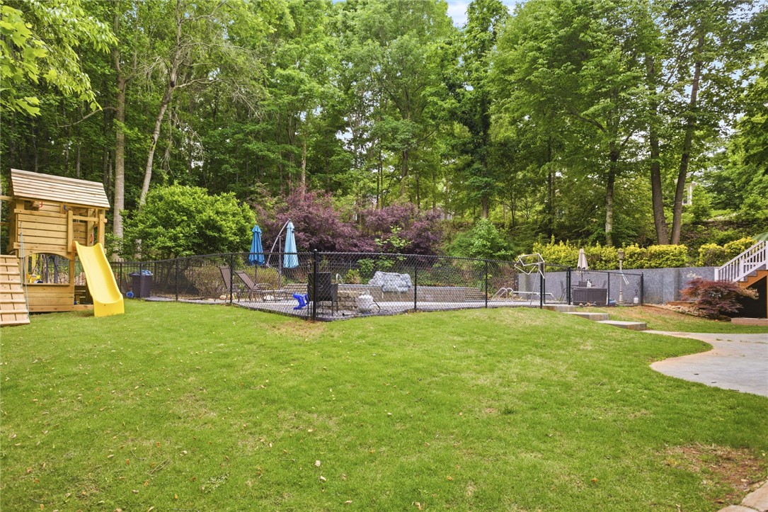 207 Devonhurst Drive Seneca, SC 29678 - Photo 42 of 50 This lush backyard retreat features a private pool and playful outdoor amenities, perfect for leisure and recreation.
