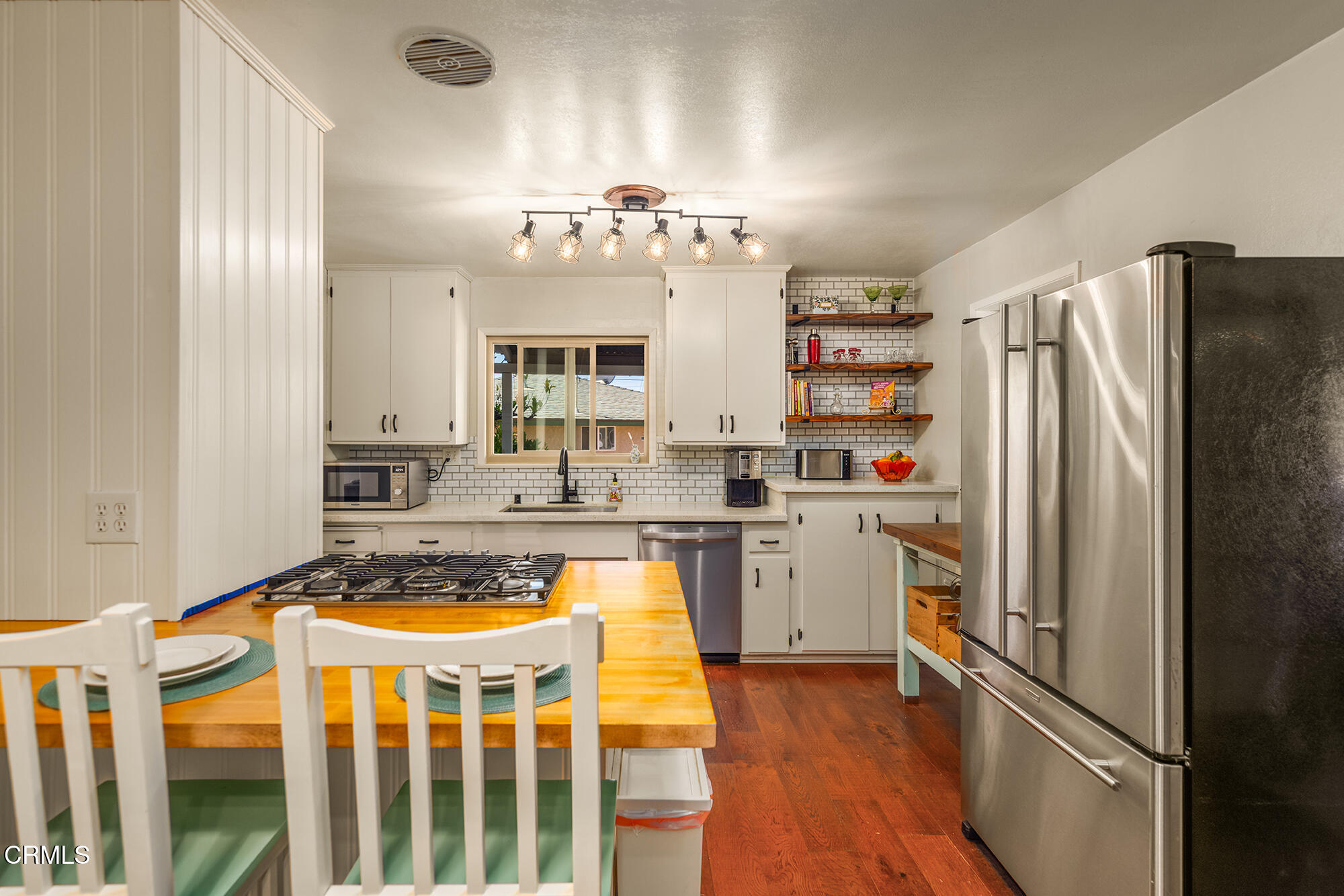 45 Rio Via Oak View, CA 93022 - Photo 13 of 34 a kitchen with a refrigerator a sink dishwasher a stove and a dining table with wooden floor